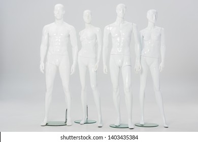 white plastic mannequins in row on grey 