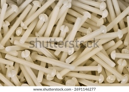 White plastic nylon machine screws scattered hardware work tools accessories computer components.