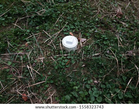white plastic sewer cleanout pipe in yard with grass