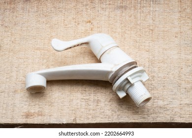 White Plastic Sink Faucet On Wood Background