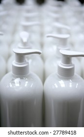 White plastic soap bottles in rows, cosmetics laboratory assembly line