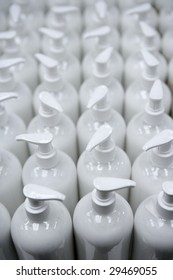 White plastic soap bottles in rows, cosmetics laboratory assembly line