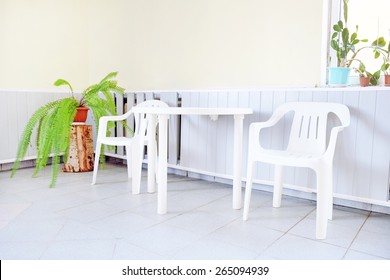 White Plastic Table And Two Chairs.