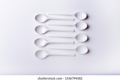 
White plastic tea spoon with a white background