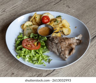 a white plate with duck confit, potatoes, salad, and a small cup of sauce - Powered by Shutterstock - Get 15% off with code: PIKWIZARD15