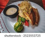 White plate with a fish fillet vegetable potato dish in Playa del Carmen Quintana Roo Mexico.