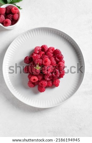 White plate with fresh rasberries. Top view food. 