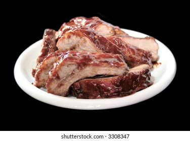 A White Plate Full Of Juicy Barbecued Baby Back Ribs, Isolated On Black