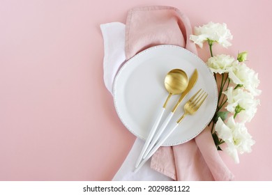 White plate, white gold colors cutlery  and white flowers table place setting  on pink background top view.  Space for text.  Holiday, birthday, wedding invitation template. - Powered by Shutterstock