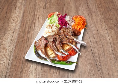 White Plate With Lamb Chop  And Vegetables On Wooden Table