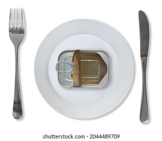 A White Plate Plate With An Opened Empty Tin Can Surrounded By Fork, And Knife Culery. Scarcity Of Food And World Hunger And Inequality Concept. Top View Isolated On White Background.