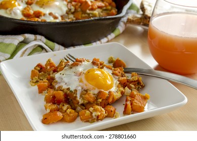 White Plate With Single Fried Egg And Sweet Potato Hash With Fork, Grapefruit Juice And Whole Grain Toast