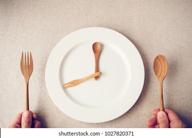 white plate with spoon and fork, Intermittent fasting concept, ketogenic diet, weight loss,  food crisis, restaurant and cafe reopening post covid-19 coronavirus pandemic - Shutterstock ID 1027820371