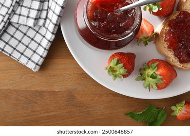 White plate with strawberry jam and slice of bread with jam spread and fruit on wooden table and white checkered napkin. Top view. - Powered by Shutterstock