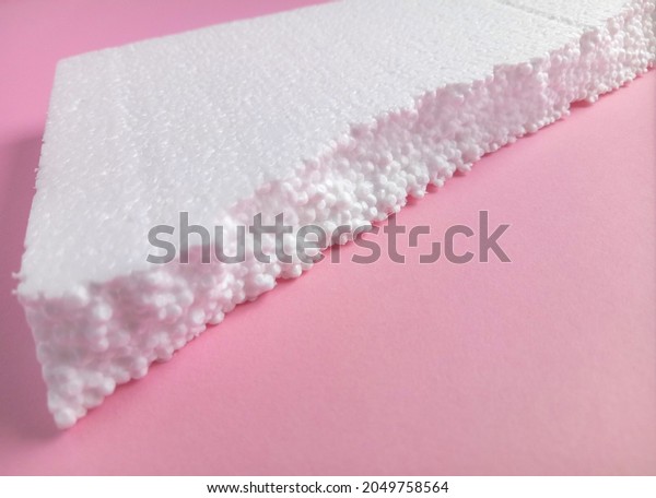 white polystyrene foam on pink cardboard.\
Fractional porous polystyrene foam. bearing materials for packaging\
and other industries
