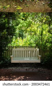 A White Porch Swing On A Summer Afternoon.                            