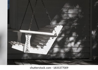 White Porch Swing In Sunlight And Shadow