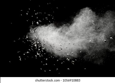 White powder with small stones isolated on black background. Small granite rock stone fly on dust against dark background.