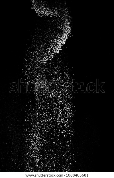 White powder\
splash isolated on black background. Flour sifting on a black\
background. Explosive powder\
white