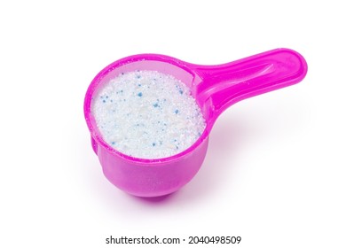 White powdered laundry detergent in plastic measuring scoop on a white background