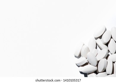 White Prescription Pills Tipped Out and Spilled from container bottle on white background, drug addiction concept, pharmaceuticals, medicine and medical concept