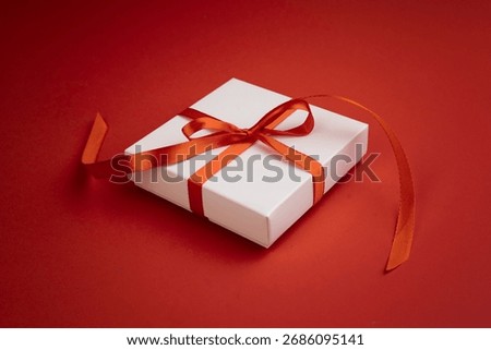 White present box decorated with red ribbon closeup. Christmas gift. Single object.Promotion,discount concept.Valentine's day.