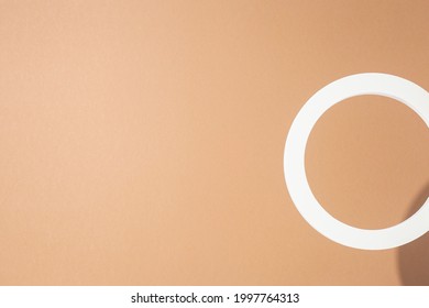 White presentation ring on a light brown background. Top view, flat lay.