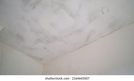 White primed ceiling. Whitewashing the ceiling with a hand roller. Painted ceiling with white paint.