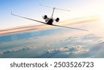 A white private jet in flight against a blue sky with white clouds