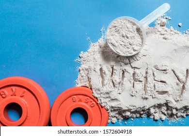 White Protein Powder With The Word Whey And Red Discs On Blue Background