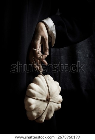 white pumpkin tied with string and hanging from one hand IV, spain