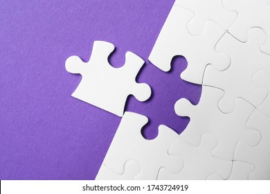 White puzzle with unfitting piece on purple background, flat lay