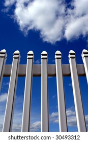 White PVC Yard Picket Fence Over Cloudy Blue Sky