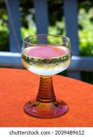 White Quality Riesling Wine Served In Yellow Swirl Wine Glass On Outdoor Terrace In Mosel River Wine Region, Germany