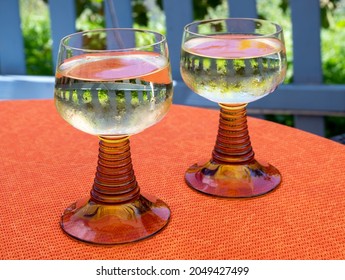 White Quality Riesling Wine Served In Yellow Swirl Wine Glass On Outdoor Terrace In Mosel River Wine Region, Germany