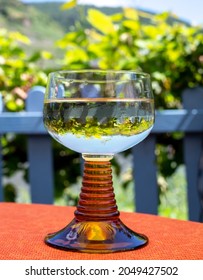 White Quality Riesling Wine Served In Yellow Swirl Wine Glass On Outdoor Terrace In Mosel River Wine Region, Germany