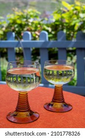 White Quality Riesling Wine Served In Yellow Swirl Wine Glass On Outdoor Terrace In Mosel River Wine Region, Germany