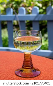 White Quality Riesling Wine Served In Yellow Swirl Wine Glass On Outdoor Terrace In Mosel River Wine Region, Germany