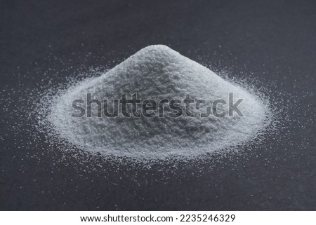 White quartz sand on a gray background in the form of a slide. quartz sand is used in finishing construction materials, water treatment and agriculture