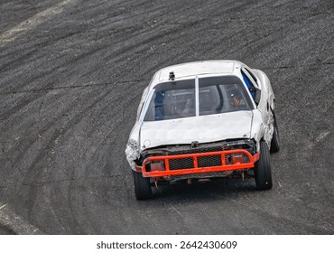 A WHITE RACE CAR WITH A ORANGE BUMBER ENTERING A CORNER AT THE RACE TRACK AT THE EVERGREEN STATE FAIRGROUNDS IN MONROE WASHINGTON