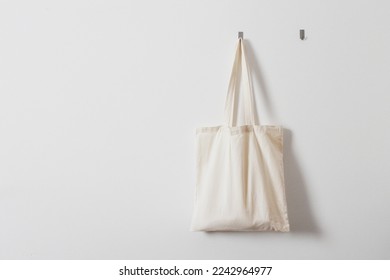 White rag bag for groceries. Reusable bag. Vegetarianism, raw food diet, conscious consumption, tissue. Hanging white fabric bag on a hook - Powered by Shutterstock