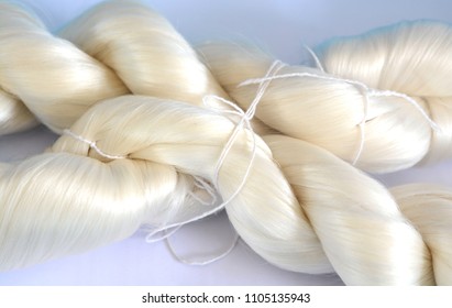 White raw silk extracted from Silk Cocoons that were produced by Silkworms.