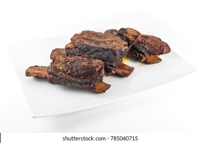 White Rectangular Plate With Three Cooked Beef Ribs Isolated On White Background
