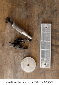 White Rectangular and Round Safety Reflectors with Rivets and Punch Tool on Wooden Workbench, Top View Flat Lay, Concept of Road Equipment Assembly, Maintenance, and Traffic Safety
