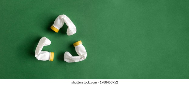White recycle sign created of plastic bottles on green background flat lay with copy space. PET recycling concept. - Shutterstock ID 1788453752