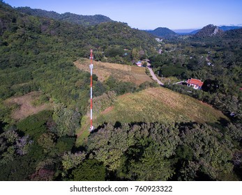 White And Red Cell Phone Tower In Small Village On The Mountain.