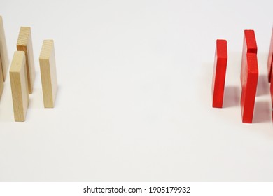 White and red dominoes stand opposite each other. A chain reaction on a white background. Isolate. Conceptual: confrontation, disagreement, different views, business, decision-making. Empty space.