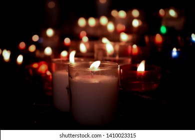White, red, green, and blue candles with bokeh and black vignette - Shutterstock ID 1410023315