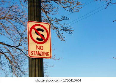 White And Red Sign Screwed Onto Metal Pole At Belle Isle State Park That Reads NO STANDING With A Red Circle And Slash Through A Capital S. Signs Like These Are Common In Urban Areas.