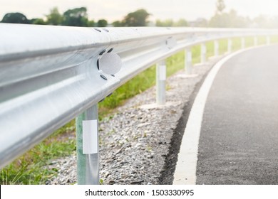 White reflective sign warn curve at night on the steel guard rail on the road in day time.